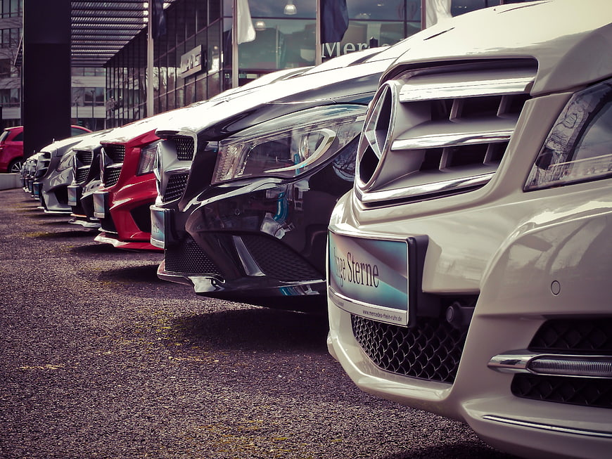 Row of luxury Mercedes-Benz cars parked at dealership