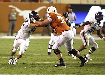 Texas Longhorns Football Player Blocking Opponent on Field