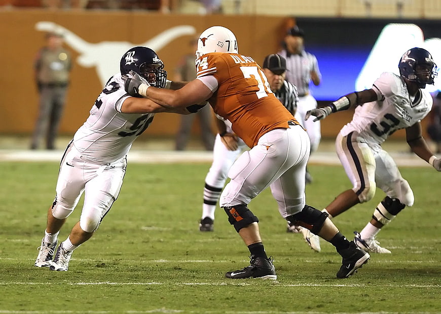 Texas Longhorns Football Player Blocking Opponent on Field