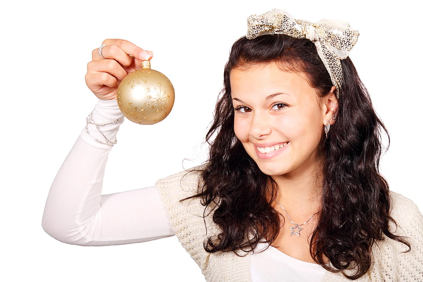 Smiling Woman Holding Gold Christmas Ornament on White Background