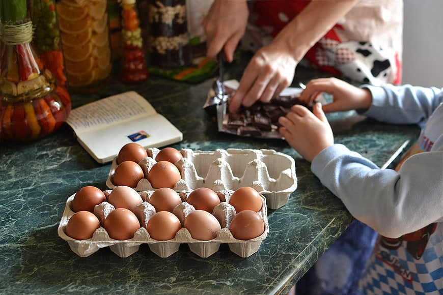 Family baking Easter eggs with chocolate and ingredients
