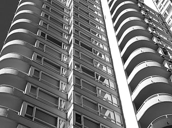 Black and white low angle view of modern apartment building facade