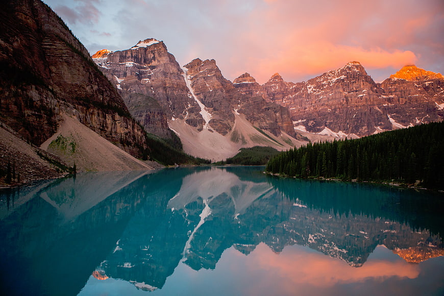 Majestic mountain reflection in turquoise lake at sunset