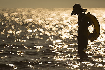 Silhouette of Lifeguard with Lifebuoy in Sparkling Ocean