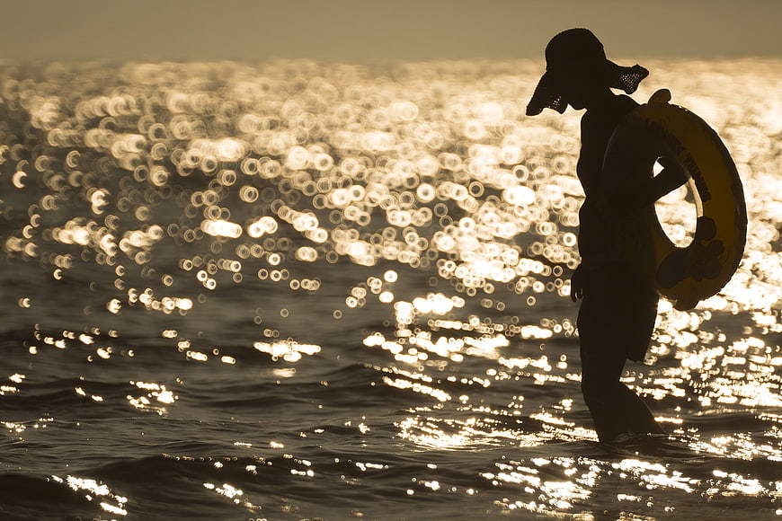 Silhouette of Lifeguard with Lifebuoy in Sparkling Ocean