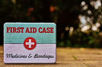Vintage First Aid Tin Box on Wooden Surface