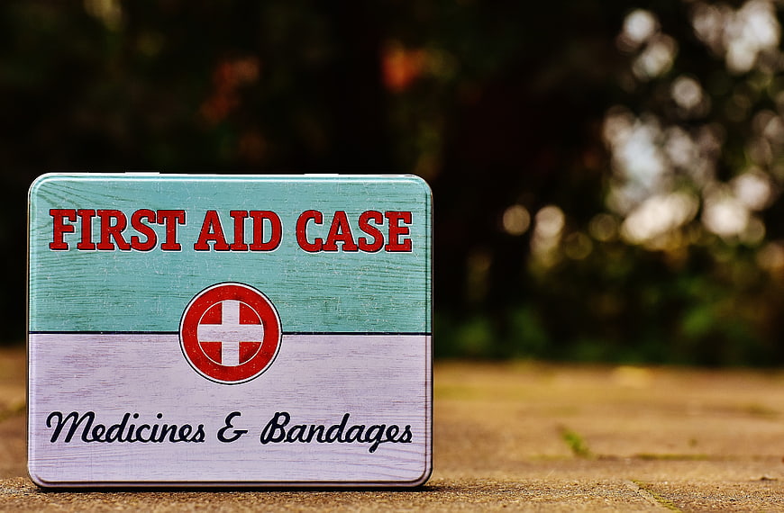 Vintage First Aid Tin Box on Wooden Surface