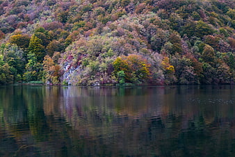 Serene autumn lake with colorful forest reflections