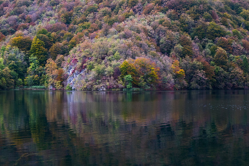 Serene autumn lake with colorful forest reflections