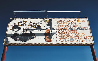 Vintage Jackass Gas Station Sign Against Blue Sky