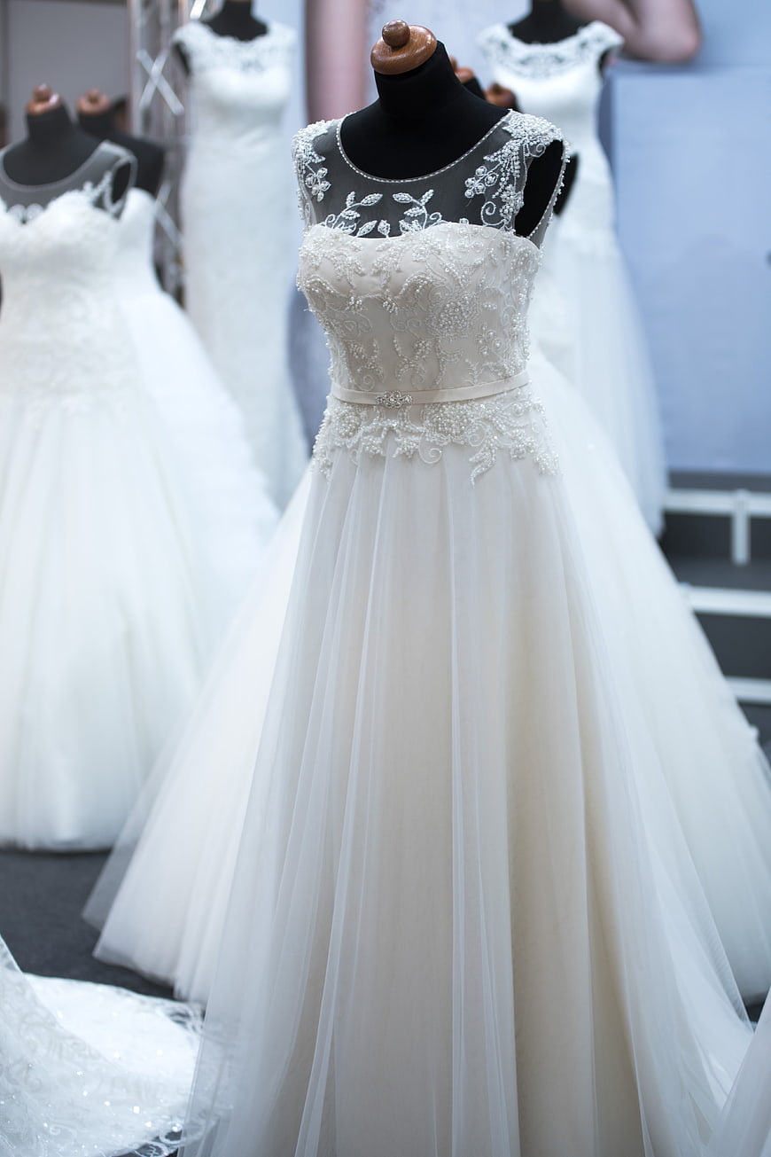 Elegant white wedding dress with beaded bodice on mannequin