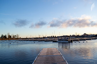 Wooden Dock Leading to Calm Harbor at Sunset