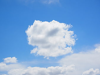 Fluffy White Cloud Against Bright Blue Sky Background