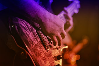 Close-up of hands playing electric guitar on stage