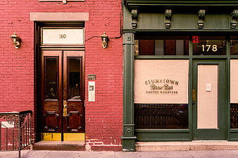Red brick building facade with green coffee shop storefront
