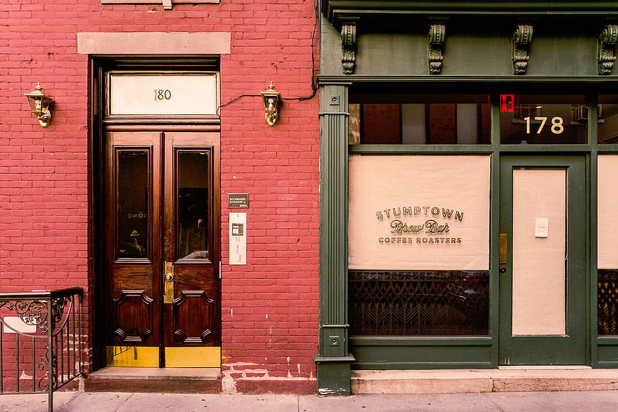 Red brick building facade with green coffee shop storefront