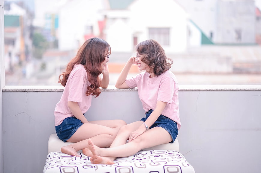 Two Happy Women Laughing Together on Balcony