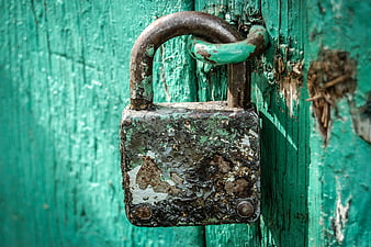 Rusty Vintage Padlock on Weathered Green Wooden Door