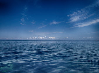 Calm Blue Ocean Horizon with Clouds