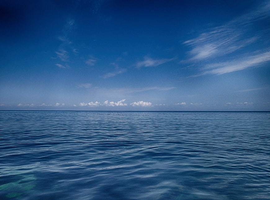 Calm Blue Ocean Horizon with Clouds