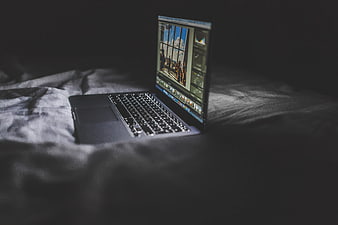 Laptop on Bed with Photo Editing Software