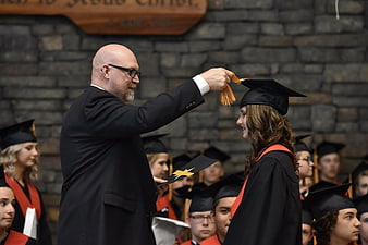 Professor Adjusting Graduation Cap at Ceremony