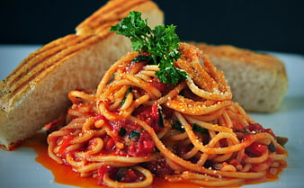 Spaghetti with tomato sauce and bread on a white plate
