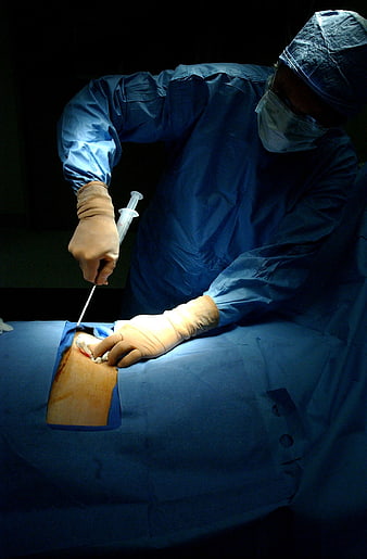 Surgeon performing bone marrow harvest procedure in operating room