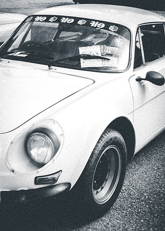 Vintage white classic car with racing decals and grainy film texture