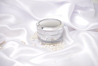 Luxury skincare cream jar on white silk with pearls