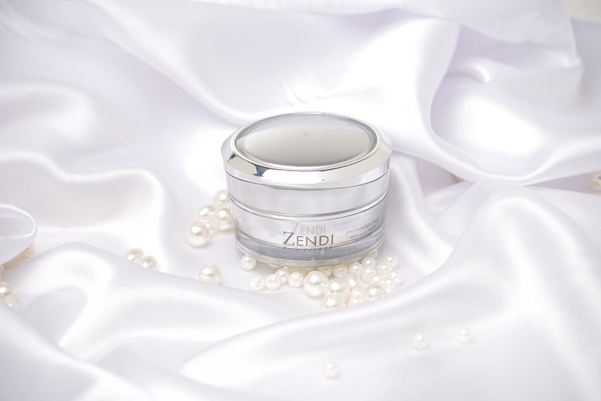 Luxury skincare cream jar on white silk with pearls