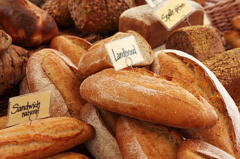 Fresh artisan bread loaves with labels in bakery basket