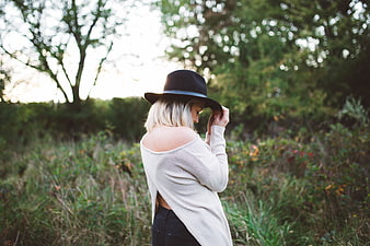 Blonde Woman in Hat Standing in Nature