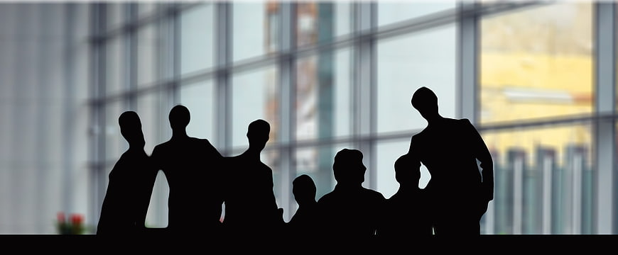 Silhouettes of business team collaborating in modern office