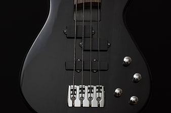 Close-up of black electric bass guitar body and bridge
