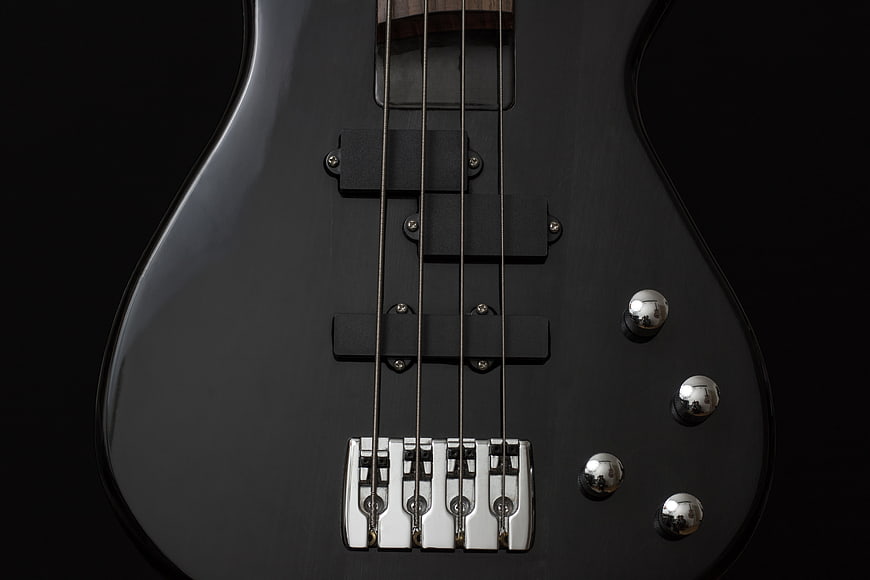 Close-up of black electric bass guitar body and bridge
