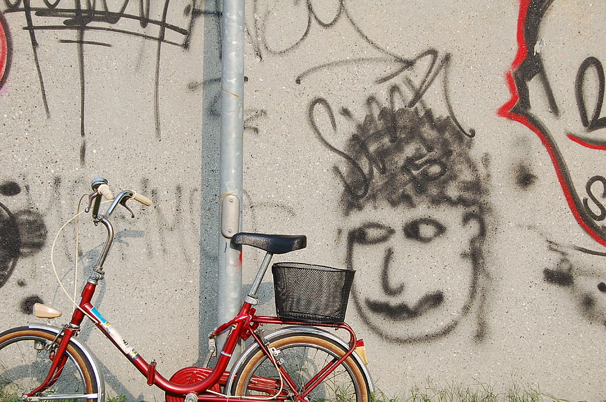 Red Bicycle Parked Against Graffiti Wall