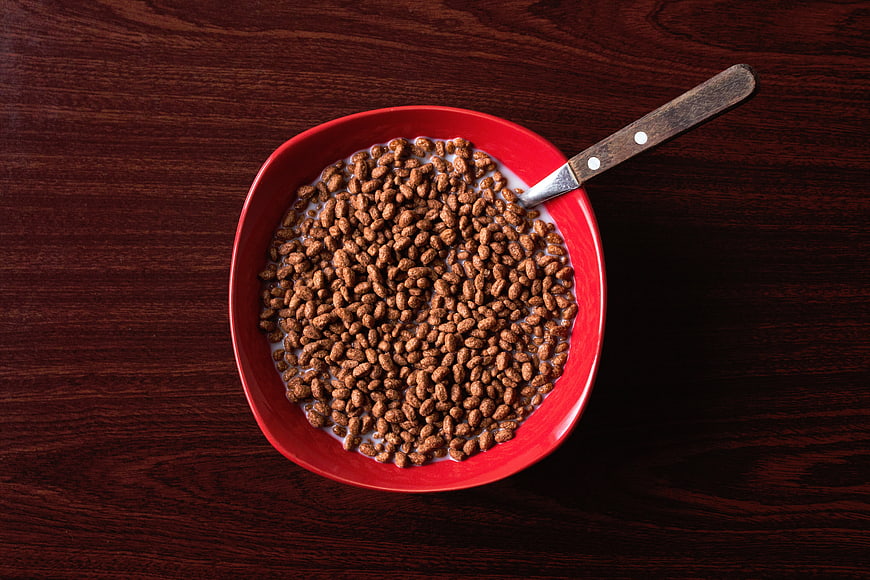 Top View of Chocolate Cereal in Red Bowl with Milk