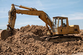 Yellow Excavator Digging Dirt at Construction Site