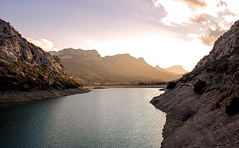 Serene Mountain Lake at Golden Hour with Dramatic Sunlight