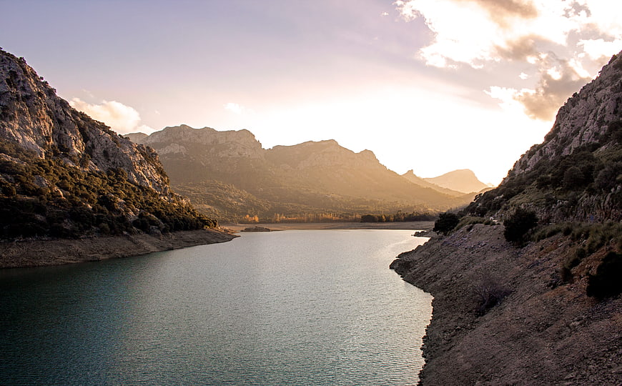 Serene Mountain Lake at Golden Hour with Dramatic Sunlight