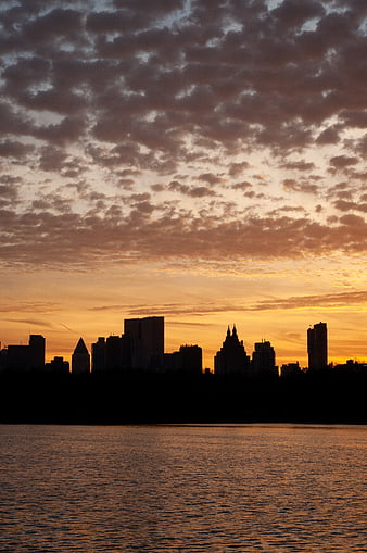 Silhouetted City Skyline at Sunset Over Water