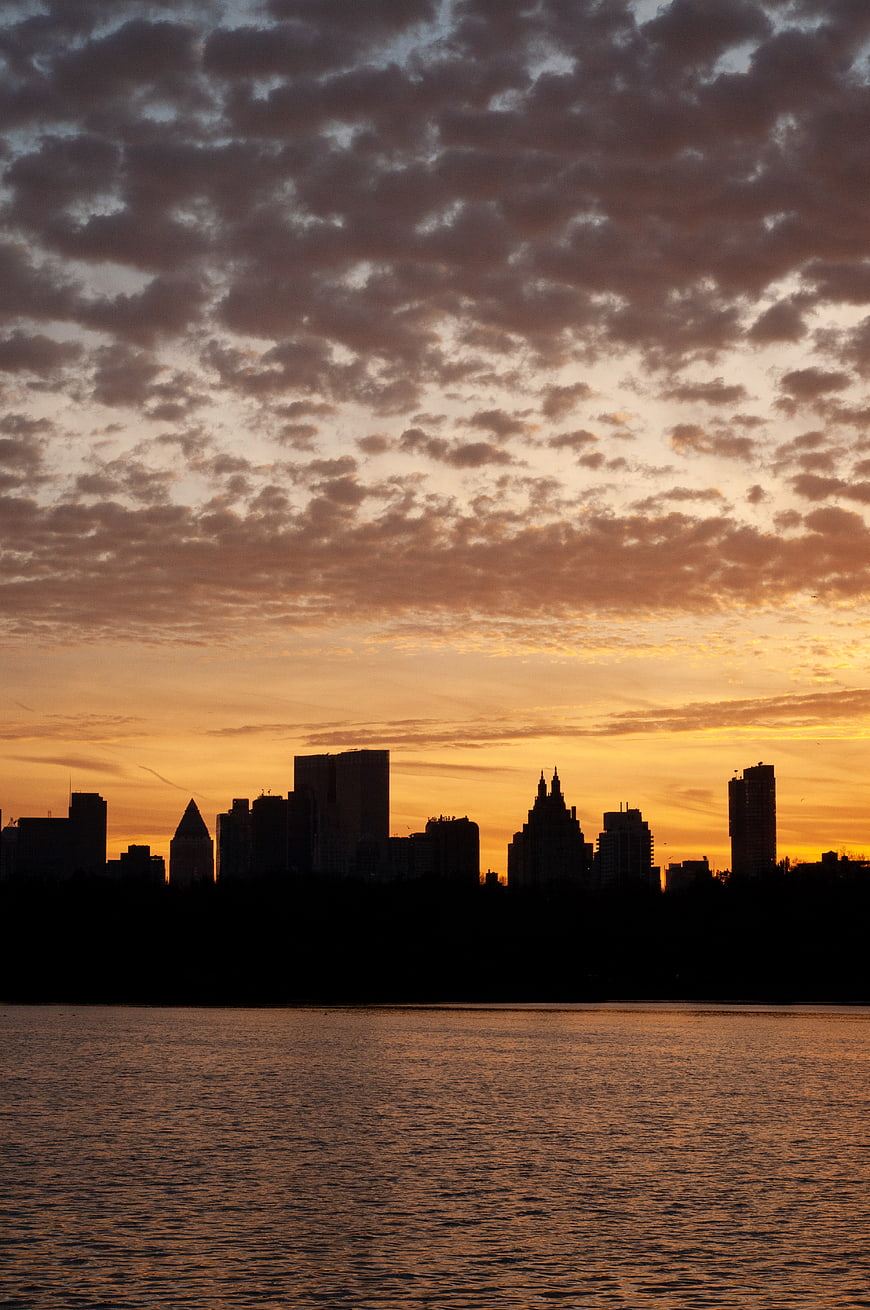 Silhouetted City Skyline at Sunset Over Water