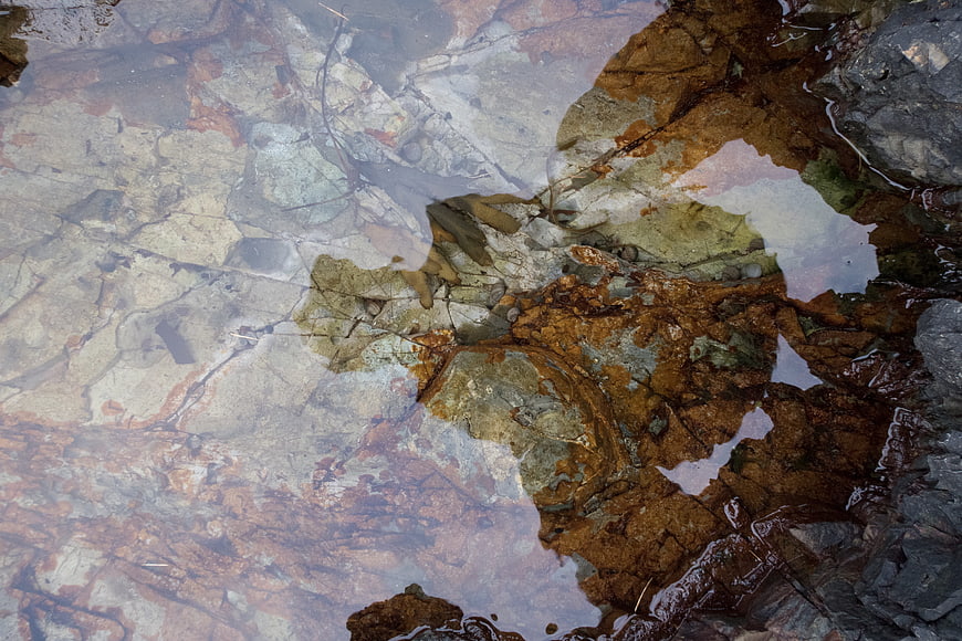 Abstract Texture of Wet Rocks and Clear Water Reflections
