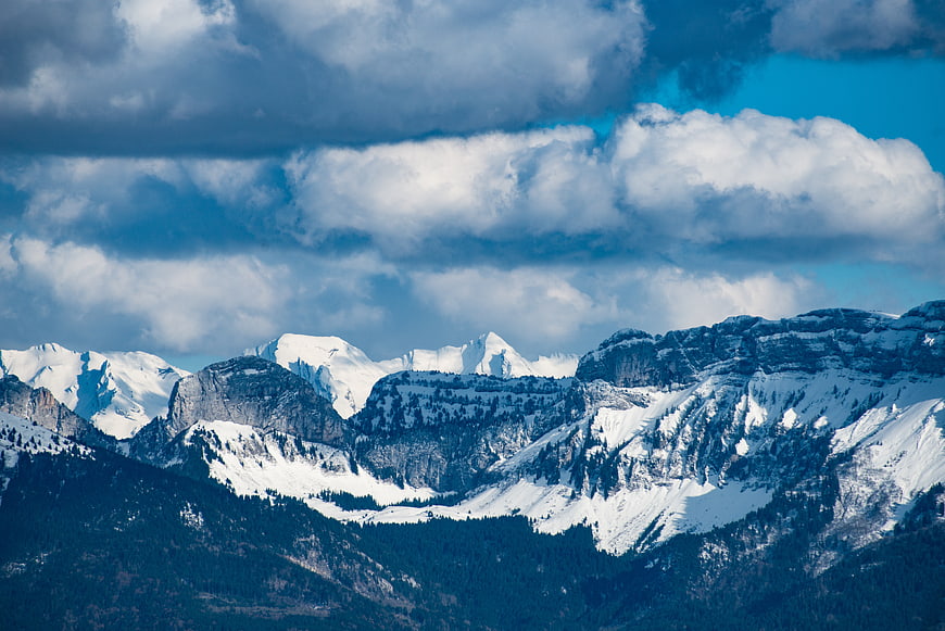 Snow-Capped Mountain Peaks Under Dramatic Cloudy Sky