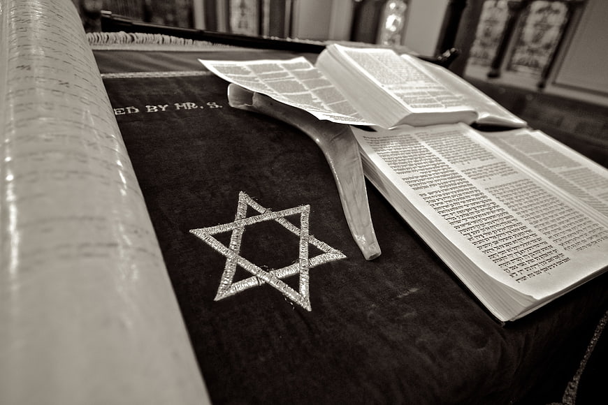 Sepia toned Star of David on Torah scroll and open Hebrew prayer book