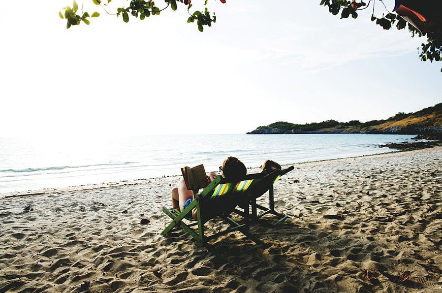 Woman Reading Book on Beach Chair Relaxing