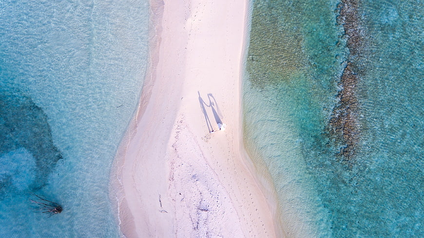 Aerial view of couple shadows on tropical sandbar