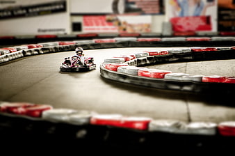 Go-kart racing on indoor track with motion blur