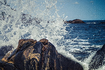 Powerful Ocean Wave Splashing Against Rocky Coastline